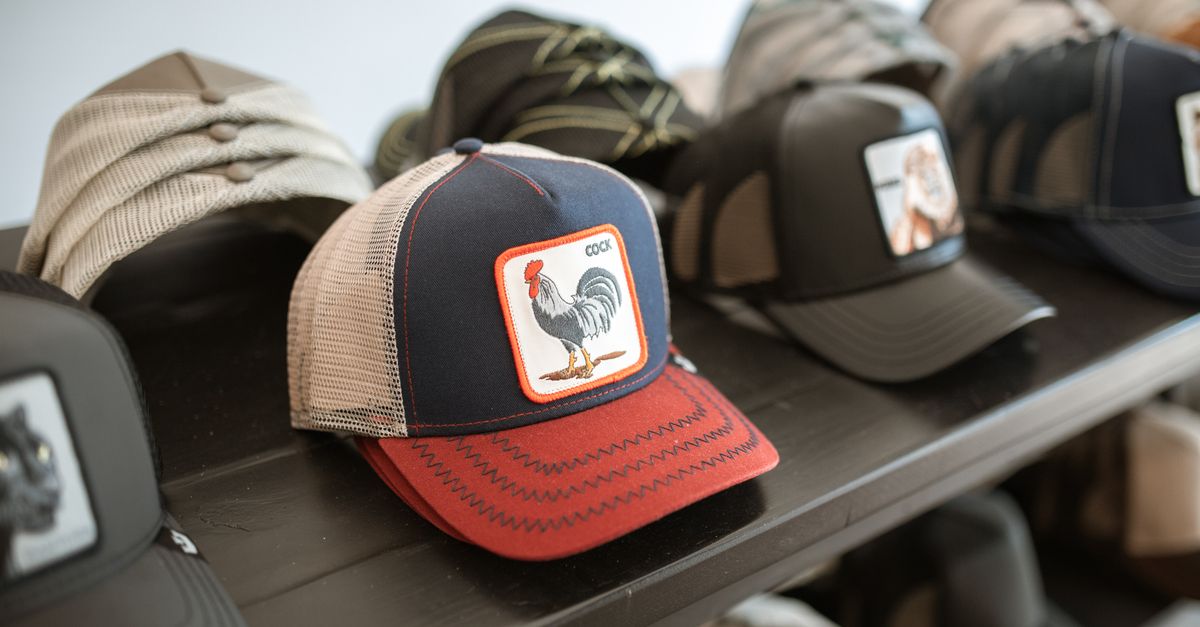 Collection of fashionable graphic caps displayed on a shelf, highlighting unique rooster design.
